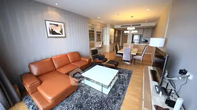 Spacious modern living room with leather sofa and open dining area