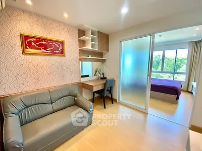 Modern living room with stylish decor and view into cozy bedroom