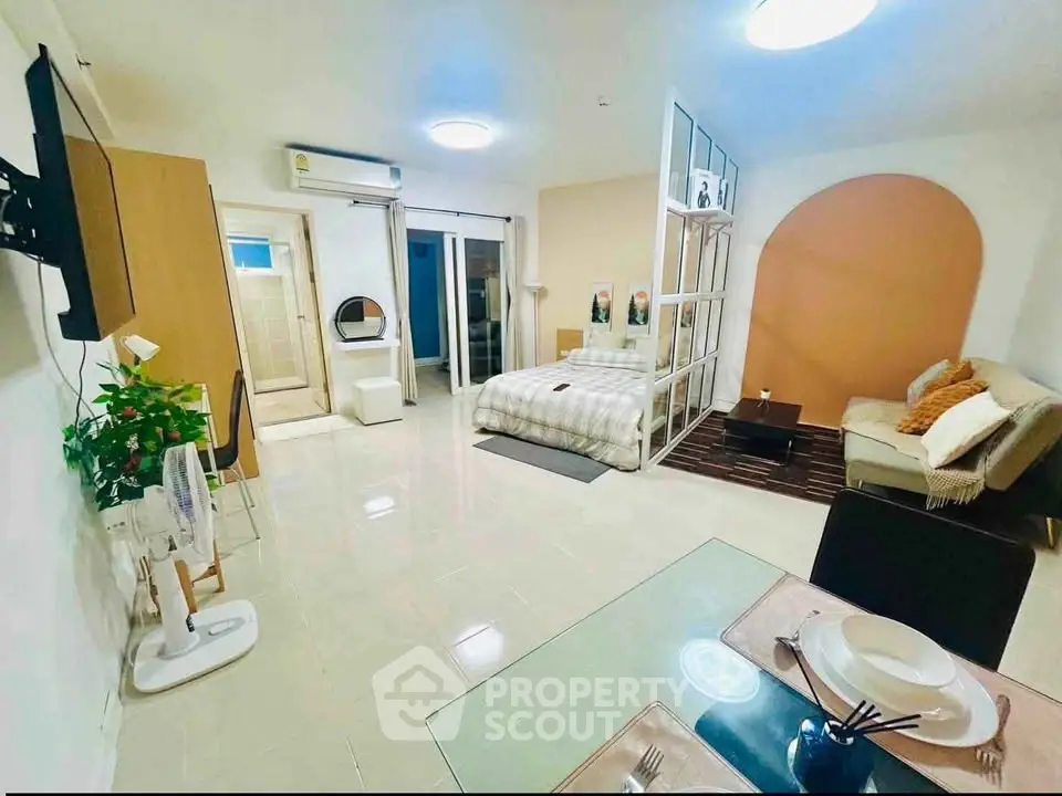 Spacious studio apartment with modern decor and open layout, featuring cozy living area and dining space.