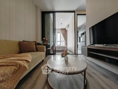 Modern living room with cozy sofa, stylish coffee table, and large TV, leading to a bright bedroom.
