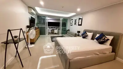 Spacious modern bedroom with stylish decor and large windows offering natural light.