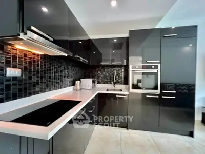 Modern kitchen with sleek black cabinetry and built-in appliances