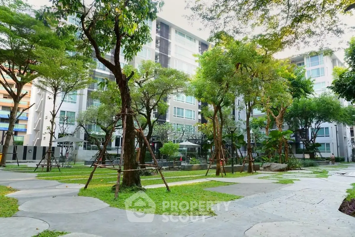 Modern apartment building with lush garden and trees, offering serene urban living.