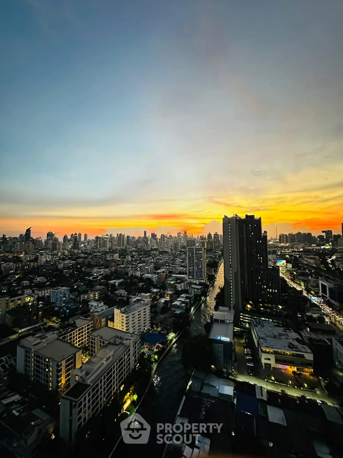 Stunning cityscape view at sunset from a high-rise building, showcasing urban skyline and vibrant colors.