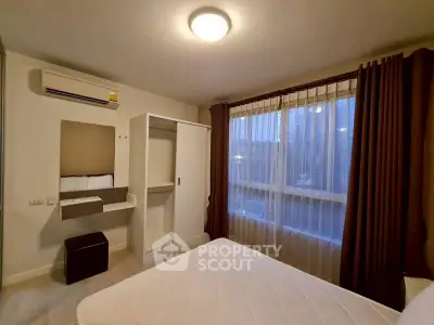 Cozy bedroom with large window and air conditioning in modern apartment