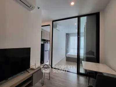 Modern apartment interior with open living space and glass partitioned bedroom