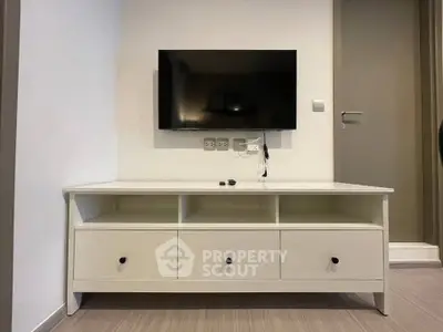 Modern living room with wall-mounted TV and sleek white console table.