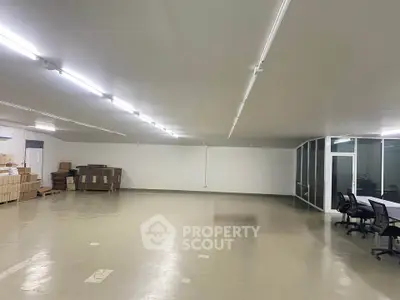 Spacious industrial warehouse with ample lighting and office space, ideal for storage or business operations.