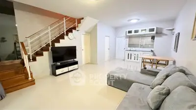 Spacious living room with modern staircase and open kitchen layout
