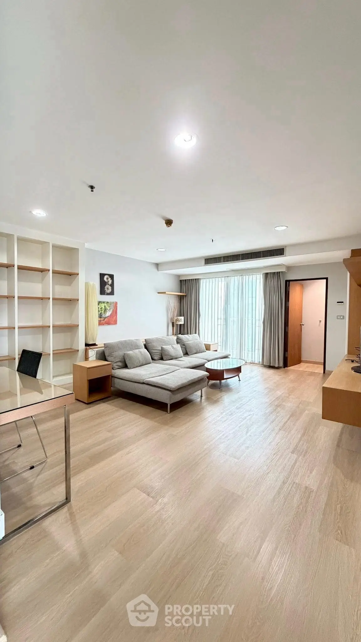 Spacious modern living room with elegant wooden flooring and stylish furniture