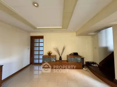Spacious living room with modern decor and elegant staircase