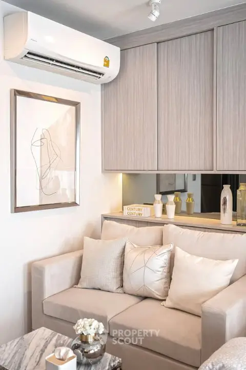 Modern living room with stylish decor and air conditioning unit, featuring cozy sofa and elegant wall art.