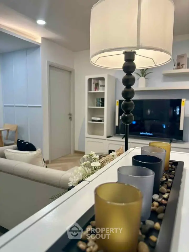 Modern living room with stylish decor and ambient lighting, featuring a cozy seating area and elegant shelving.