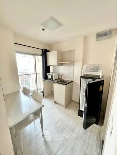 Modern kitchen with open layout and balcony view, featuring sleek appliances and stylish dining area.