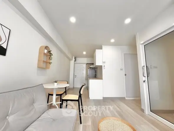 Modern open-plan living room with cozy seating and dining area, bright and inviting.