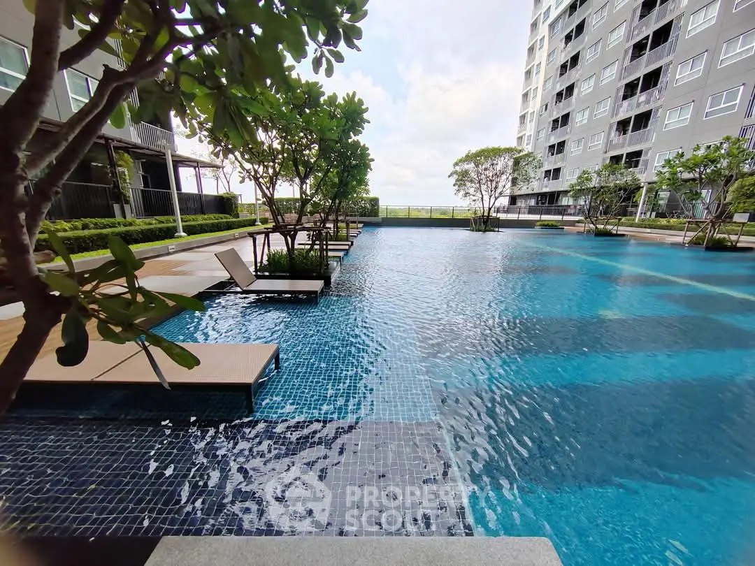 Luxurious condominium pool area with modern design and lush greenery, perfect for relaxation and leisure.