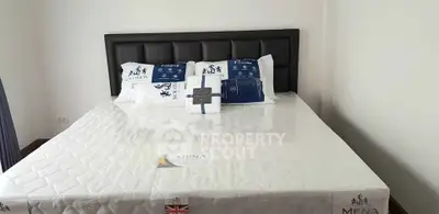 Spacious bedroom with a large bed and stylish headboard, perfect for comfort and relaxation.