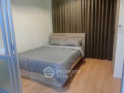Cozy bedroom with wooden flooring and modern bed, perfect for relaxation.