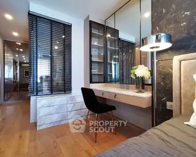 Modern bedroom with elegant decor and stylish furniture, featuring a cozy workspace and ambient lighting.