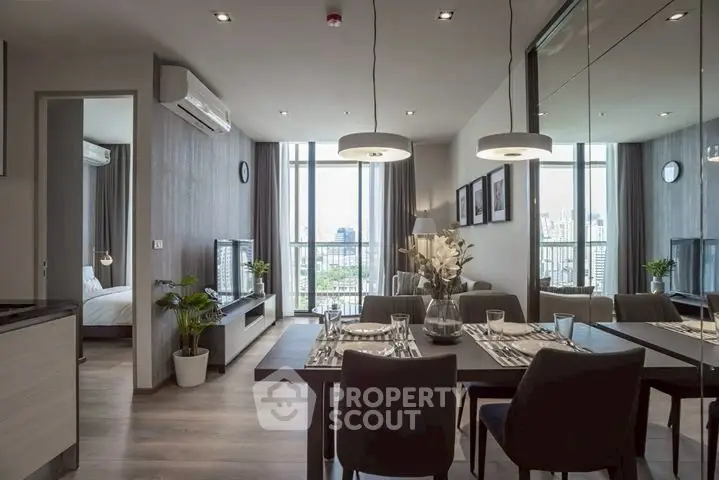 Modern open-plan living and dining area with city view and stylish decor.