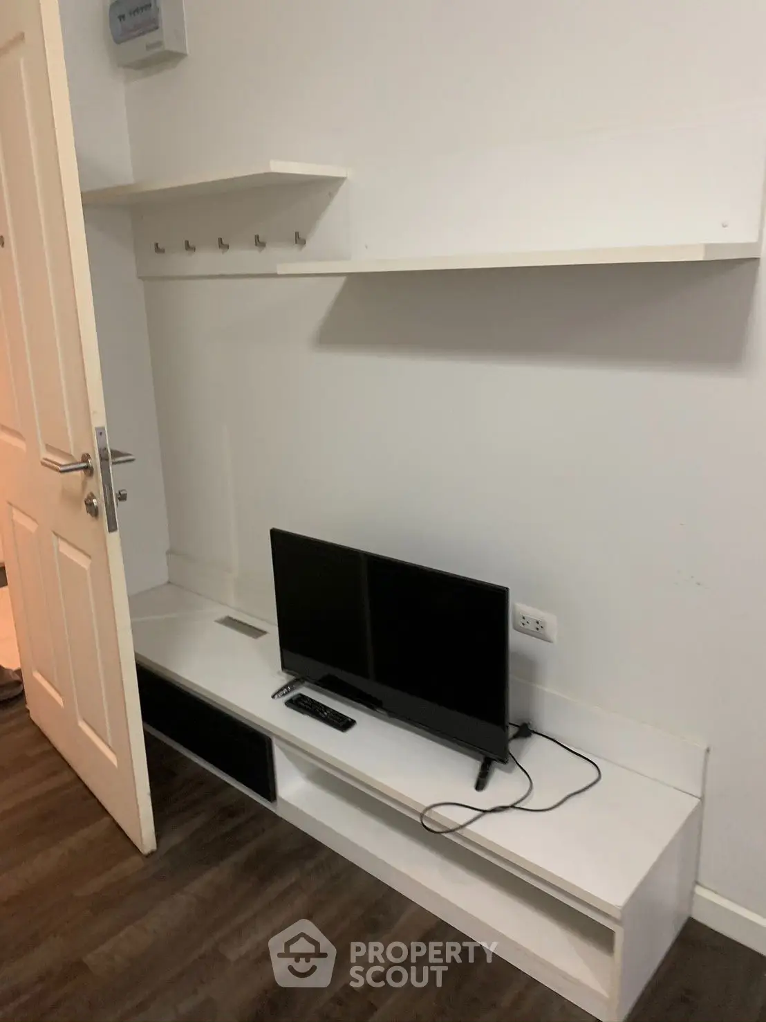 Modern living room with sleek TV stand and wall-mounted shelves, perfect for minimalist decor.