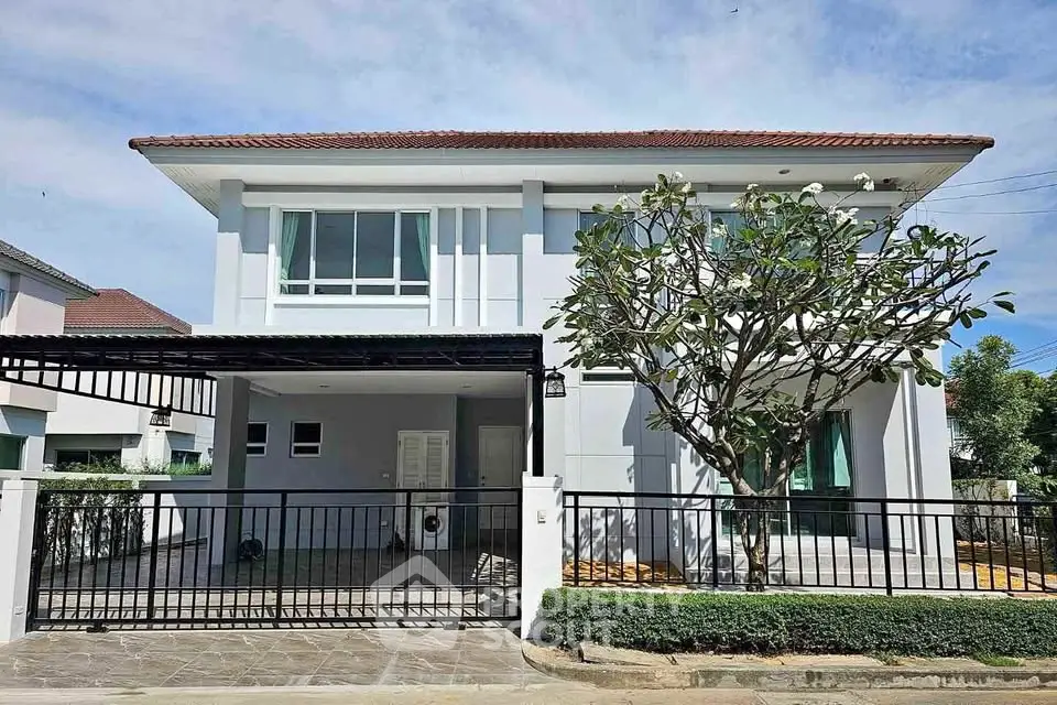 Modern two-story house with a spacious driveway and lush greenery, perfect for family living.