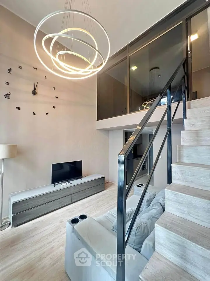 Modern living room with stylish staircase and unique wall clock design.