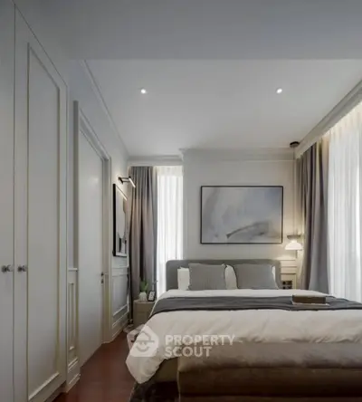 Luxurious bedroom with elegant decor and ample natural light, featuring a cozy bed and stylish furnishings.