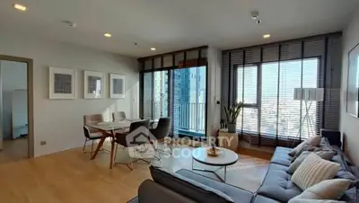 Modern living room with city view, stylish furniture, and ample natural light.