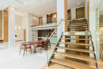 Luxurious modern living room with open layout and elegant wooden staircase