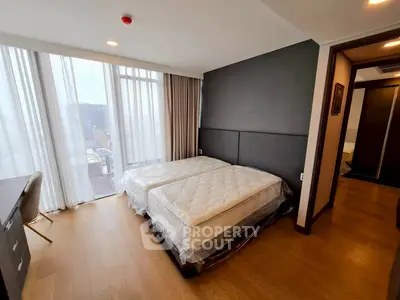 Spacious bedroom with twin beds and large windows in modern apartment