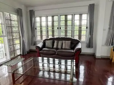 Spacious living room with large windows and elegant wooden flooring