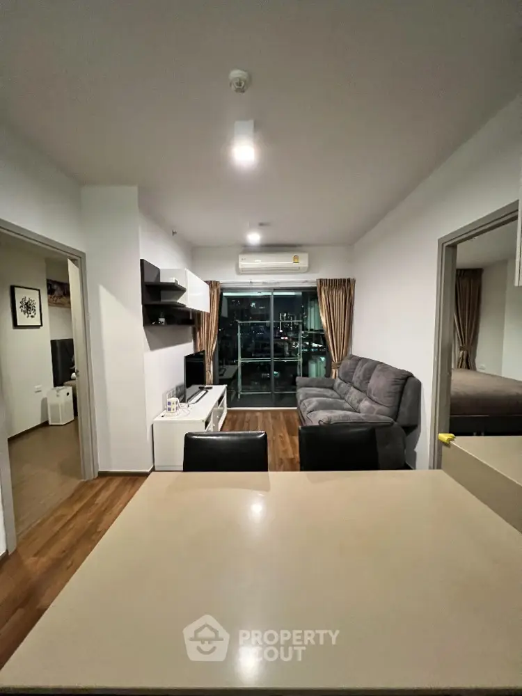 Modern living room with sleek furniture and city view balcony