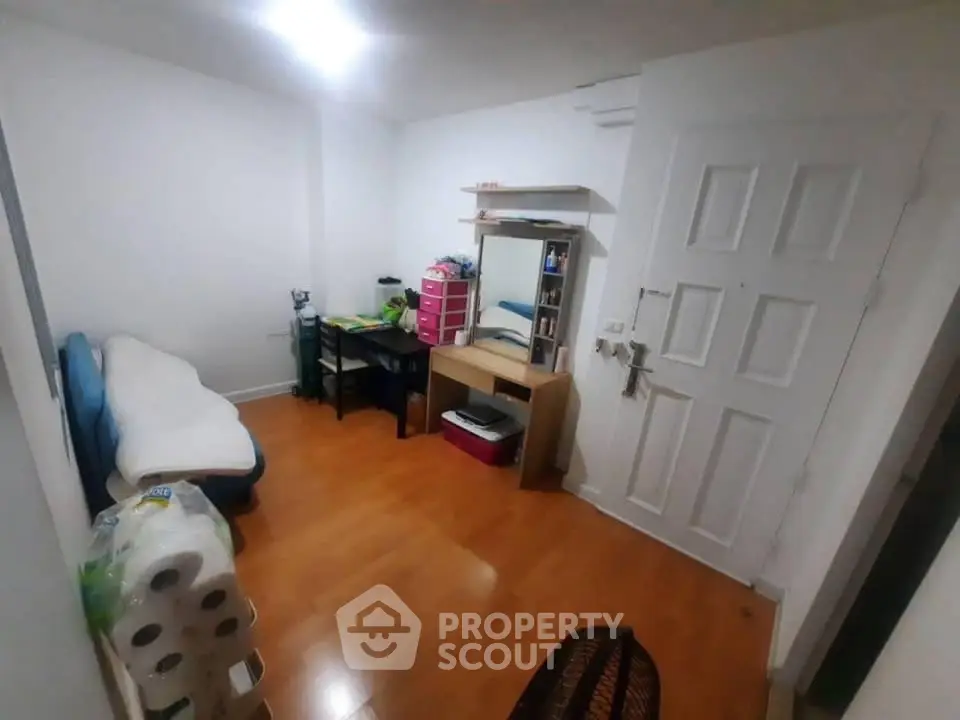 Cozy small room with wooden flooring, desk, and minimal furnishings, ideal for compact living.