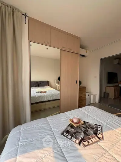 Modern bedroom with mirrored wardrobe and cozy decor in a stylish apartment.