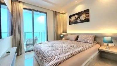 Luxurious bedroom with ocean view and modern decor, featuring a cozy bed and elegant lighting.