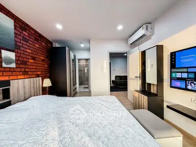 Modern bedroom with stylish decor and wall-mounted TV in a cozy apartment.