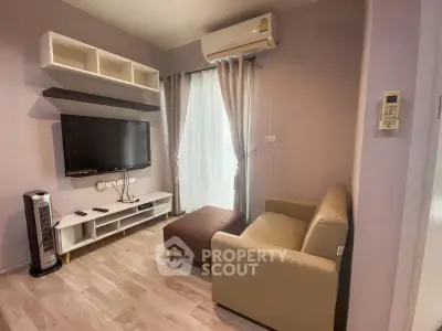 Cozy living room with modern TV setup and air conditioning, perfect for relaxation.