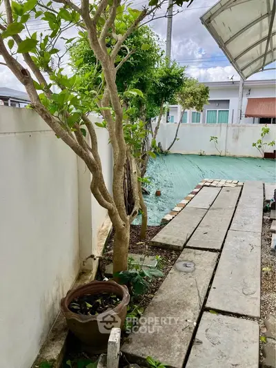 Charming garden area with lush greenery and rustic pathway, perfect for outdoor relaxation and leisure.
