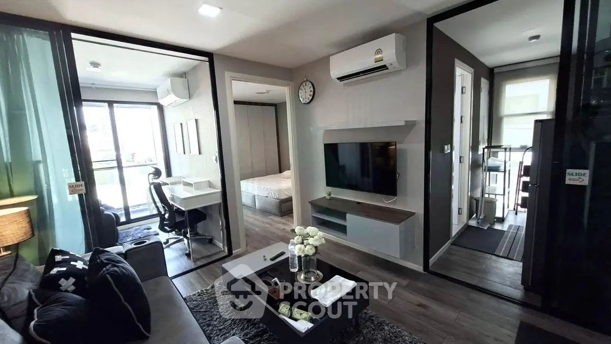 Modern apartment interior with living room, bedroom, and study area, featuring sleek design and natural light.