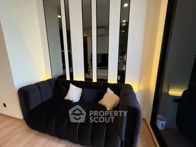 Modern living room with stylish black sofa and ambient lighting