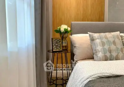 Cozy bedroom with elegant decor and soft lighting, featuring a stylish side table and plush bedding.