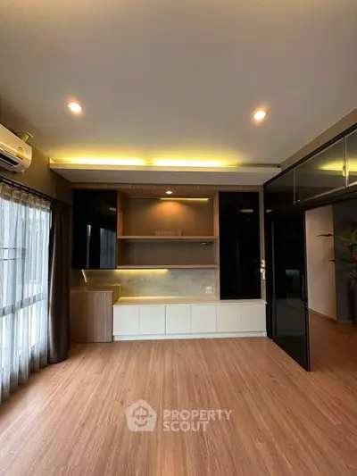 Modern living room with sleek built-in cabinets and large windows for natural light.
