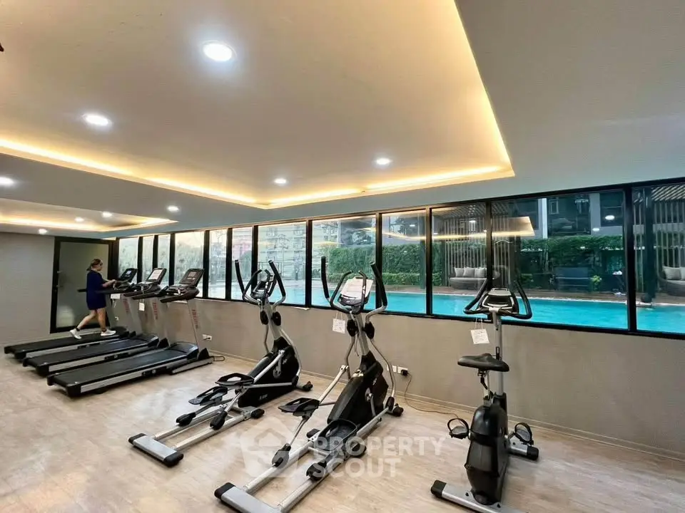 Modern gym with pool view in luxury residential complex