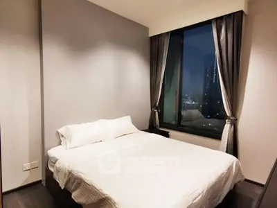 Cozy bedroom with city view, featuring a comfortable bed and elegant curtains, perfect for restful nights.