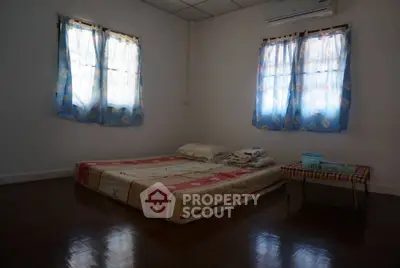 Cozy minimalist bedroom with simple mattress and air conditioning, perfect for a serene retreat.