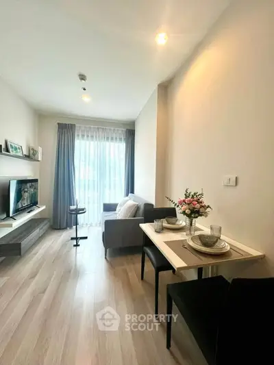Modern living room with cozy sofa, dining table, and large window for natural light.