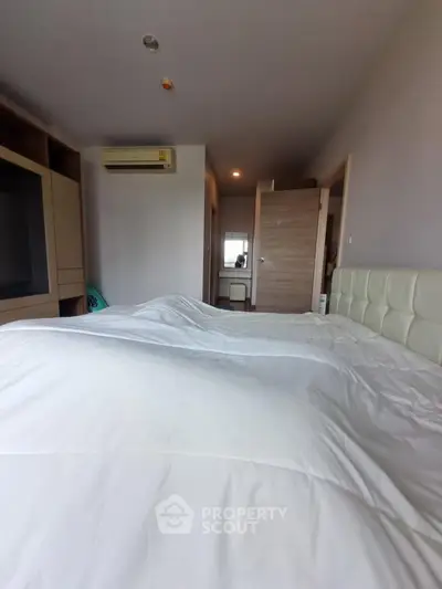 Spacious bedroom with modern decor and air conditioning in a stylish apartment.