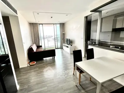 Modern living room with open kitchen and balcony view in a stylish apartment.