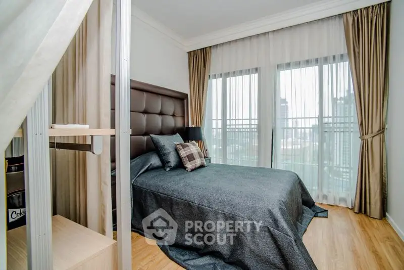 Modern bedroom with stylish decor and city view from large windows.